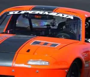 Orange race car on track, "SUPERMIATA" branding.