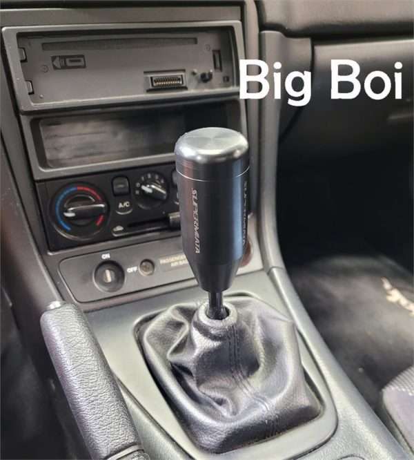 Gear shift knob with text "Big Boi" in car.