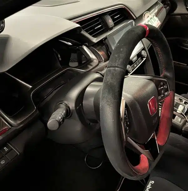 Car interior with steering wheel and dashboard.