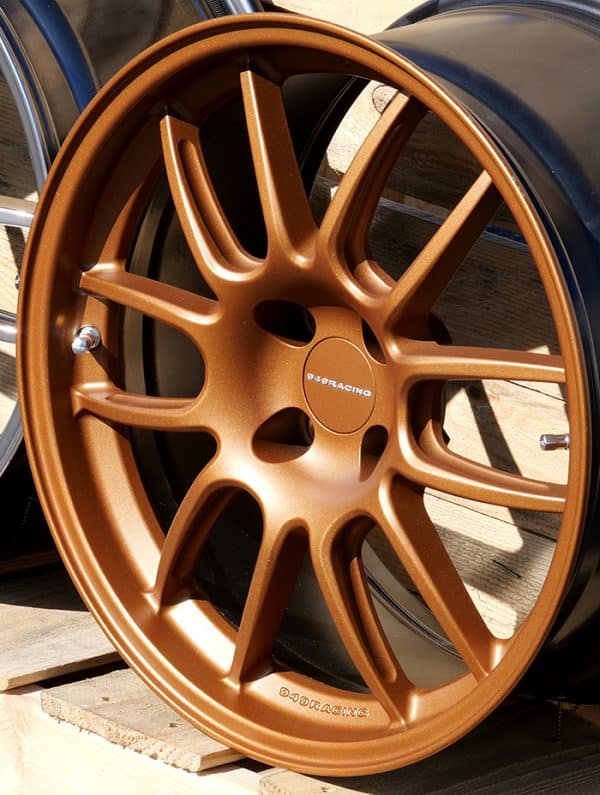 Bronze aftermarket car wheel on pallet.